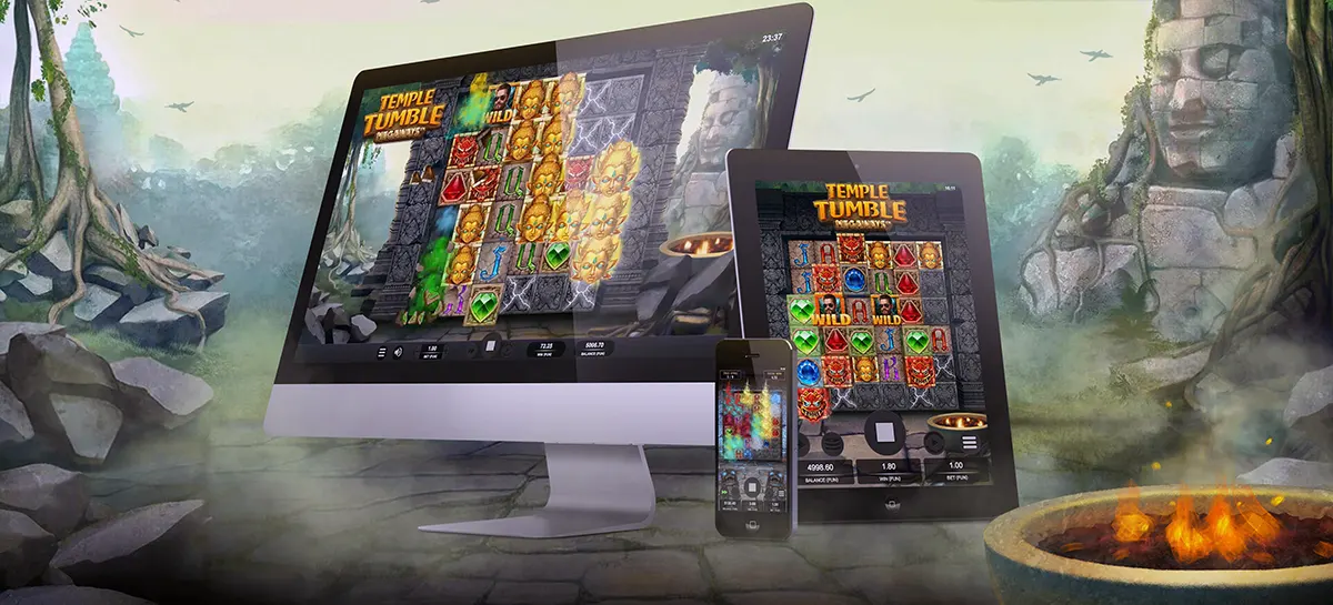 “A desktop computer, tablet, and smartphone display the Temple Tumble slot game in a jungle temple setting with stone ruins, glowing torches, and misty forest scenery in the background.”